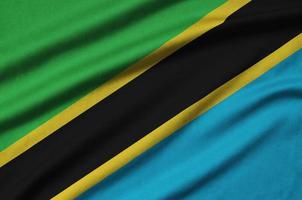 Tanzania flag is depicted on a sports cloth fabric with many folds. Sport team banner photo