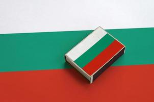 Bulgaria flag is pictured on a matchbox that lies on a large flag photo