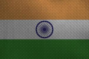 India flag depicted in paint colors on old brushed metal plate or wall closeup. Textured banner on rough background photo
