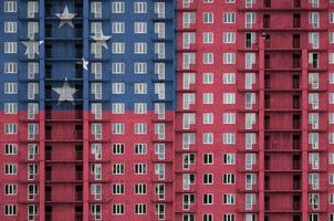 Samoa flag depicted in paint colors on multi-storey residental building under construction. Textured banner on brick wall background photo
