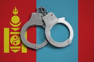 Mongolia flag and police handcuffs. The concept of observance of the law in the country and protection from crime photo