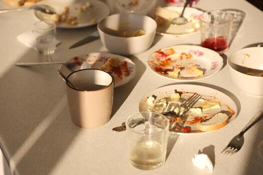 Empty dirty plates with spoons and forks on the table after meal. Banquet ending concept. Unwashed dishes photo