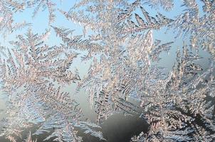 Snowflakes frost rime macro on window glass pane photo