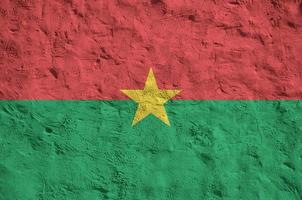 Burkina Faso flag depicted in bright paint colors on old relief plastering wall. Textured banner on rough background photo