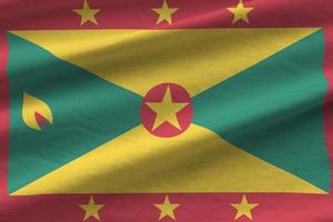 Grenada flag with big folds waving close up under the studio light indoors. The official symbols and colors in banner photo