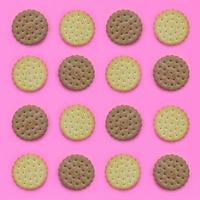 Pattern of a brown biscuits on a pink background. Trendy minimal concept of food and dessert. Abstract flat lay, top view photo