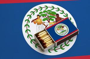 Belize flag is shown in an open matchbox, which is filled with matches and lies on a large flag photo