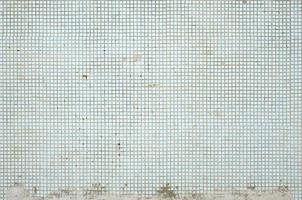The texture of the old wall, decorated with a lot of square small tiles. Wall in the style of architecture of the Soviet Union photo