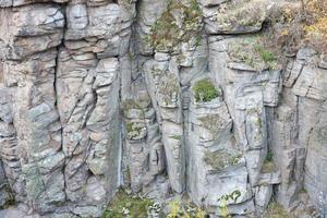 Light coarse natural rock stone background. Mining cliff rough front surface. Big limestone stack backdrop. Heavy grunge damaged granite block texture photo