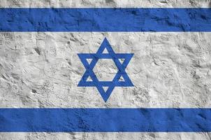 Israel flag depicted in bright paint colors on old relief plastering wall. Textured banner on rough background photo