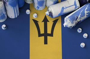 Barbados flag and few used aerosol spray cans for graffiti painting. Street art culture concept photo