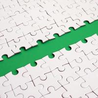 The green path is laid on the platform of a white folded jigsaw puzzle. Texture image with copy space for text photo