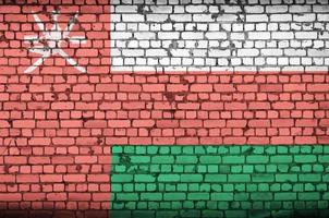 Oman flag is painted onto an old brick wall photo