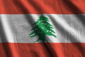 Lebanon flag with big folds waving close up under the studio light indoors. The official symbols and colors in banner photo
