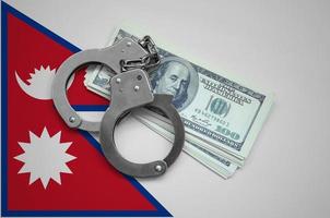 Nepal flag with handcuffs and a bundle of dollars. Currency corruption in the country. Financial crimes photo