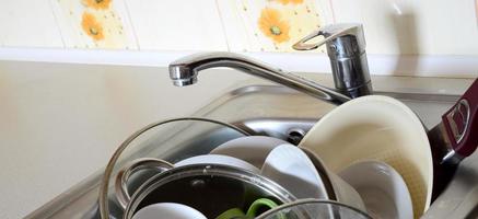 Dirty dishes and unwashed kitchen appliances filled the kitchen sink photo