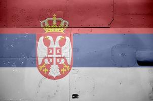 Serbia flag depicted on side part of military armored helicopter closeup. Army forces aircraft conceptual background photo