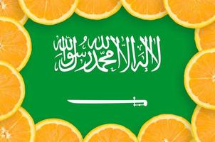 Saudi Arabia flag in fresh citrus fruit slices frame photo