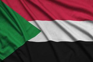 Sudan flag is depicted on a sports cloth fabric with many folds. Sport team banner photo