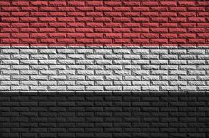 la bandera de yemen está pintada en una vieja pared de ladrillos foto