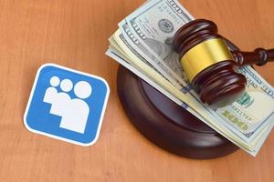 KHARKOV, UKRAINE - MAY 3, 2022 Myspace paper logo lies with judge gavel and hundred dollar bills. Entertainment lawsuit concept photo