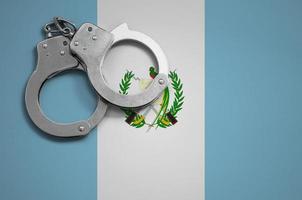 Guatemala flag and police handcuffs. The concept of crime and offenses in the country photo