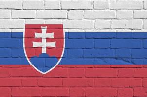 Slovakia flag depicted in paint colors on old brick wall. Textured banner on big brick wall masonry background photo