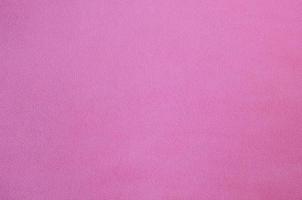 The blanket of furry pink fleece fabric. A background texture of light pink soft plush fleece material photo