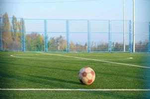 Classic soccer ball on football green grass field outdoor. Active sports and physical training photo