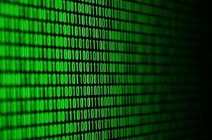 An image of a binary code made up of a set of green digits on a black background photo