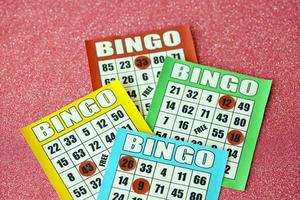 Many colorful bingo boards or playing cards for winning chips. Classic US or canadian five to five bingo cards on bright background photo