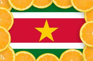 bandera de surinam en marco de rodajas de cítricos frescos foto