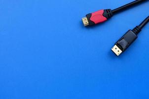 Audio video HDMI computer cable plug and 20-pin male DisplayPort gold plated connector for a flawless connection on a blue background photo