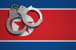 North Korea flag and police handcuffs. The concept of crime and offenses in the country photo