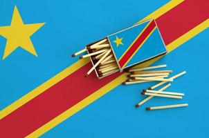 Democratic Republic of the Congo flag is shown on an open matchbox, from which several matches fall and lies on a large flag photo