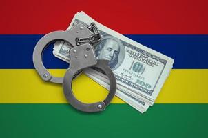 Mauritius flag with handcuffs and a bundle of dollars. Currency corruption in the country. Financial crimes photo