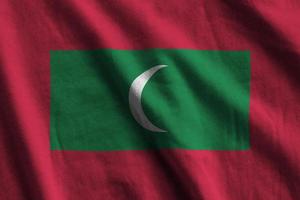 Maldives flag with big folds waving close up under the studio light indoors. The official symbols and colors in banner photo