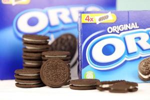 KHARKOV, UKRAINE - MAY 3, 2022 Oreo sandwich cookies and blue product boxes on white table. Oreo is a sandwich cookie with a sweet cream is the best selling cookie in the US photo