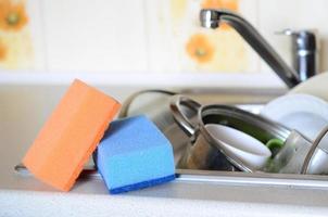 A few sponges lie on the background of the sink with dirty dishes photo