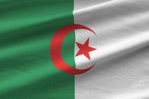 Algeria flag with big folds waving close up under the studio light indoors. The official symbols and colors in banner photo