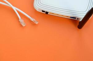 Internet router and Internet cable plugs lie on a bright orange background. Items required for Internet connection photo