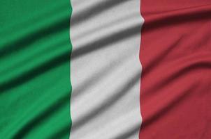 Italy flag is depicted on a sports cloth fabric with many folds. Sport team banner photo