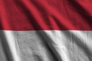 Indonesia flag with big folds waving close up under the studio light indoors. The official symbols and colors in banner photo