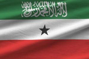 Somaliland flag with big folds waving close up under the studio light indoors. The official symbols and colors in banner photo