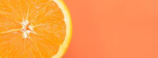 vista superior de una rodaja de fruta naranja sobre fondo brillante en color naranja. una imagen de textura cítrica saturada foto