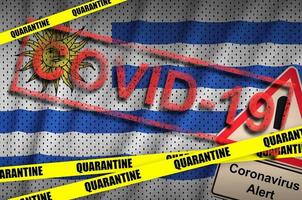 Uruguay flag and Covid-19 quarantine yellow tape with red stamp. Coronavirus or 2019-nCov virus photo