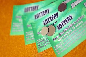 Close up view of green lottery scratch cards. Many used fake instant lottery tickets with gambling results. Gambling addiction photo