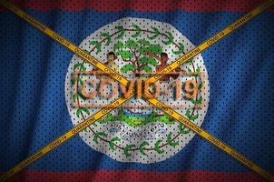 Belize flag and Covid-19 stamp with orange quarantine border tape cross. Coronavirus or 2019-nCov virus concept photo