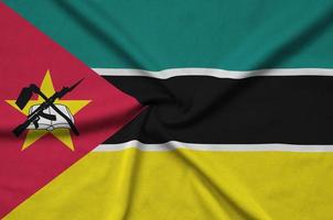 Mozambique flag is depicted on a sports cloth fabric with many folds. Sport team banner photo