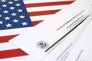 I-526 Immigrant Petition by Alien Entrepreneur blank form lies on United States flag with envelope from Department of Homeland Security photo